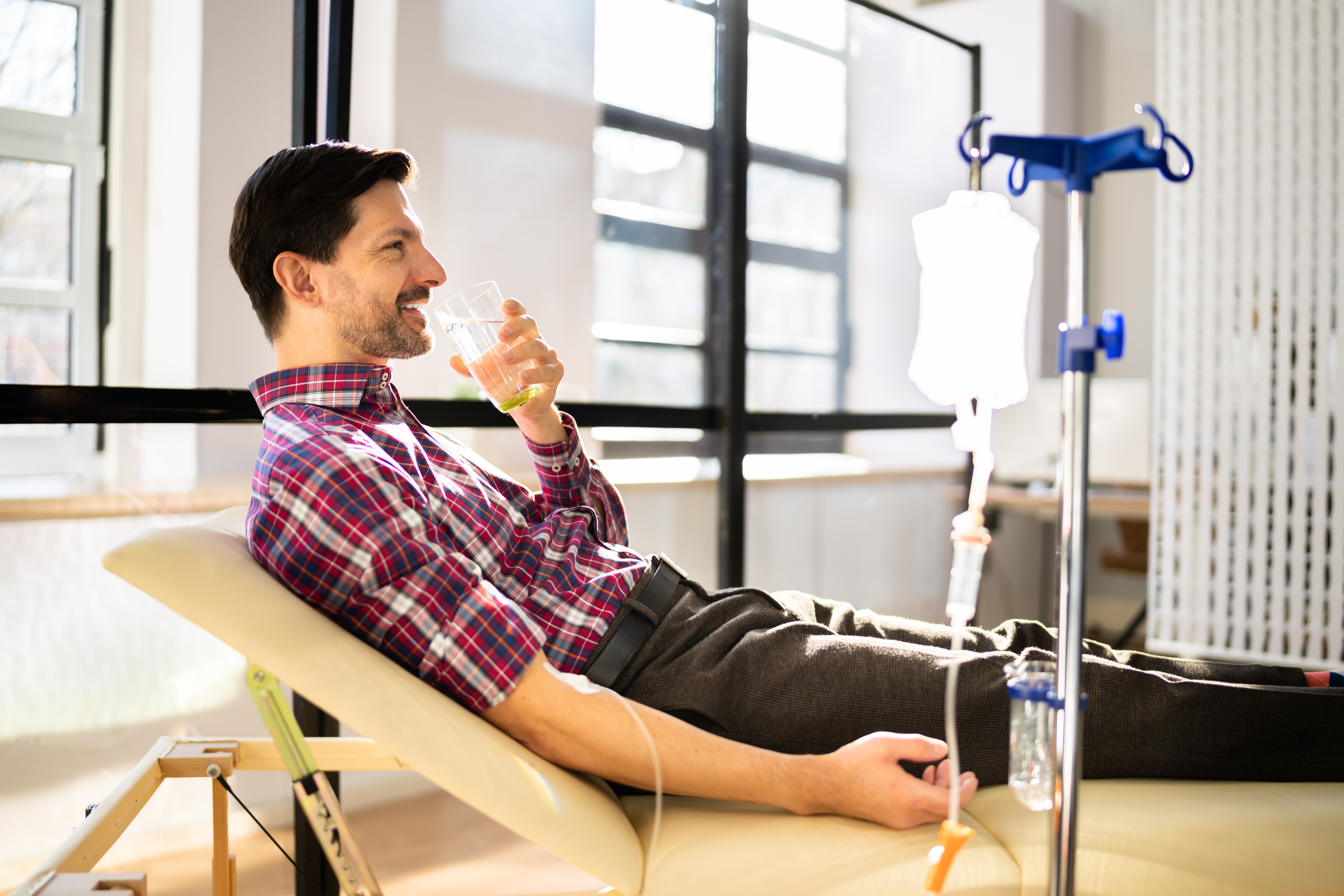 A man drinking water while receiving IV therapy in Chicago