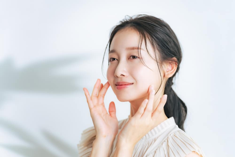 A woman touching her cheeks after a Hydrafacial in Chicago