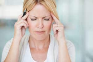 A woman with a migraine rubbing her temples
