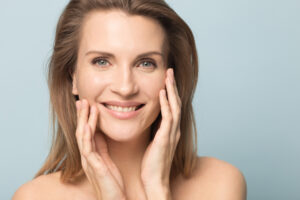 A woman touching her cheeks after Scarlet RF microneedling in Chicago