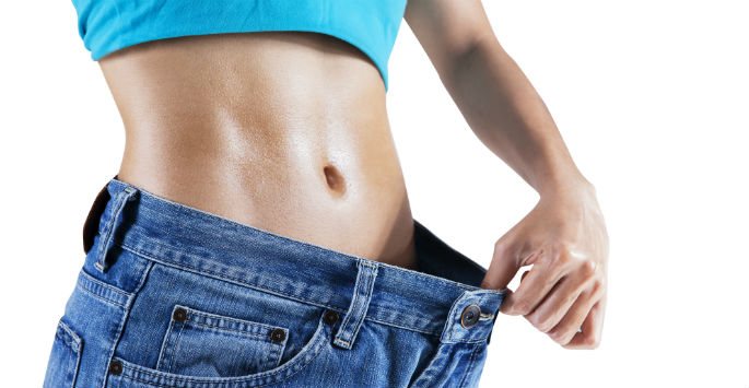 Person showing weight loss by wearing loose jeans.